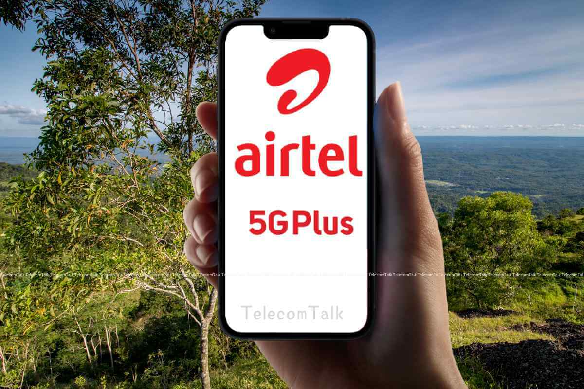 Hand holding phone with Airtel 5G Plus ad outdoors.