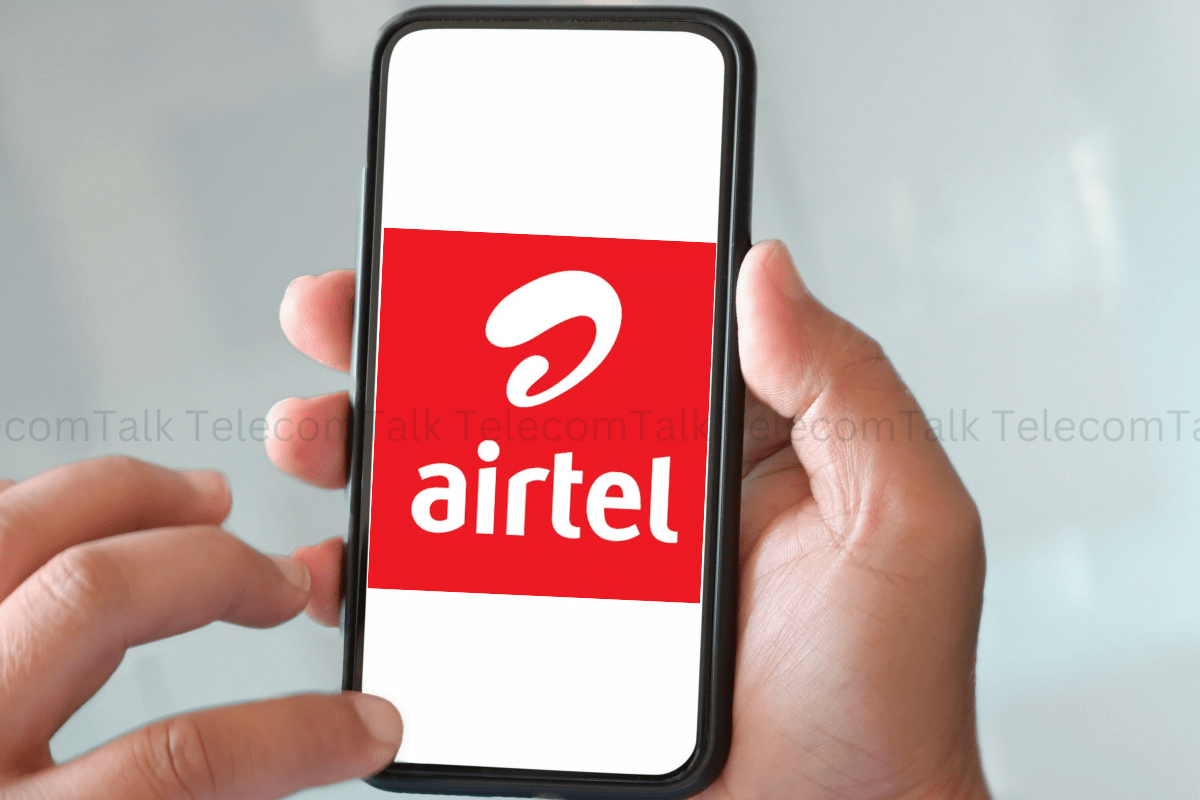 Person holding smartphone displaying Airtel logo.