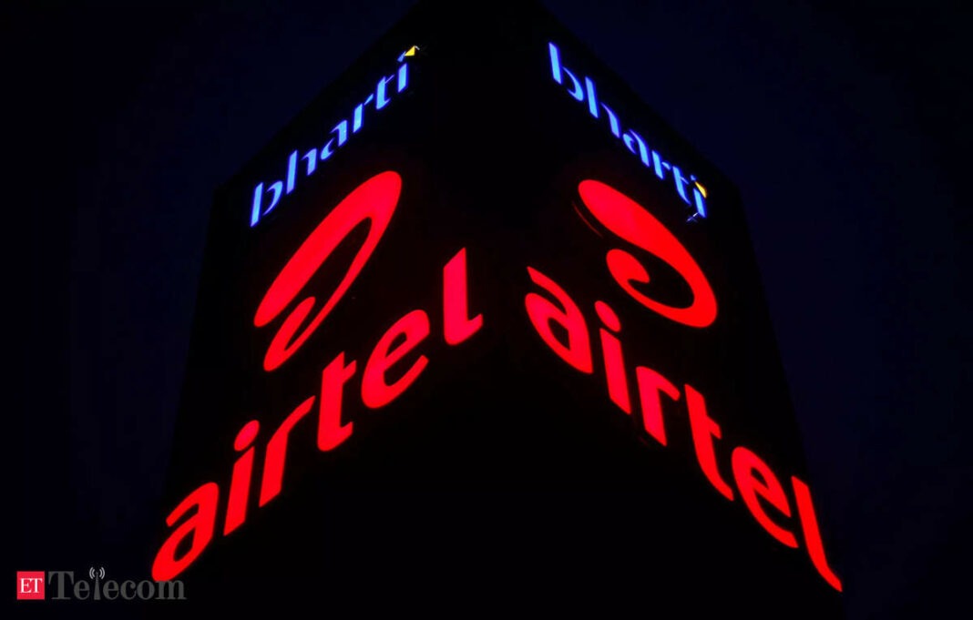 Illuminated Airtel company sign at night.
