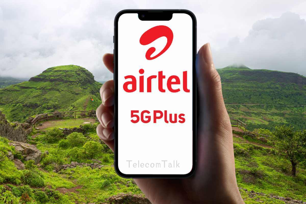 Hand holding phone with Airtel 5G Plus ad, nature background.