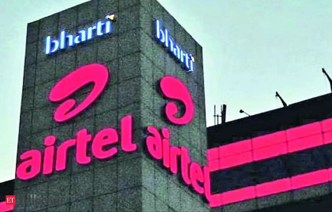 Bharti Airtel logo on building facade at dusk.