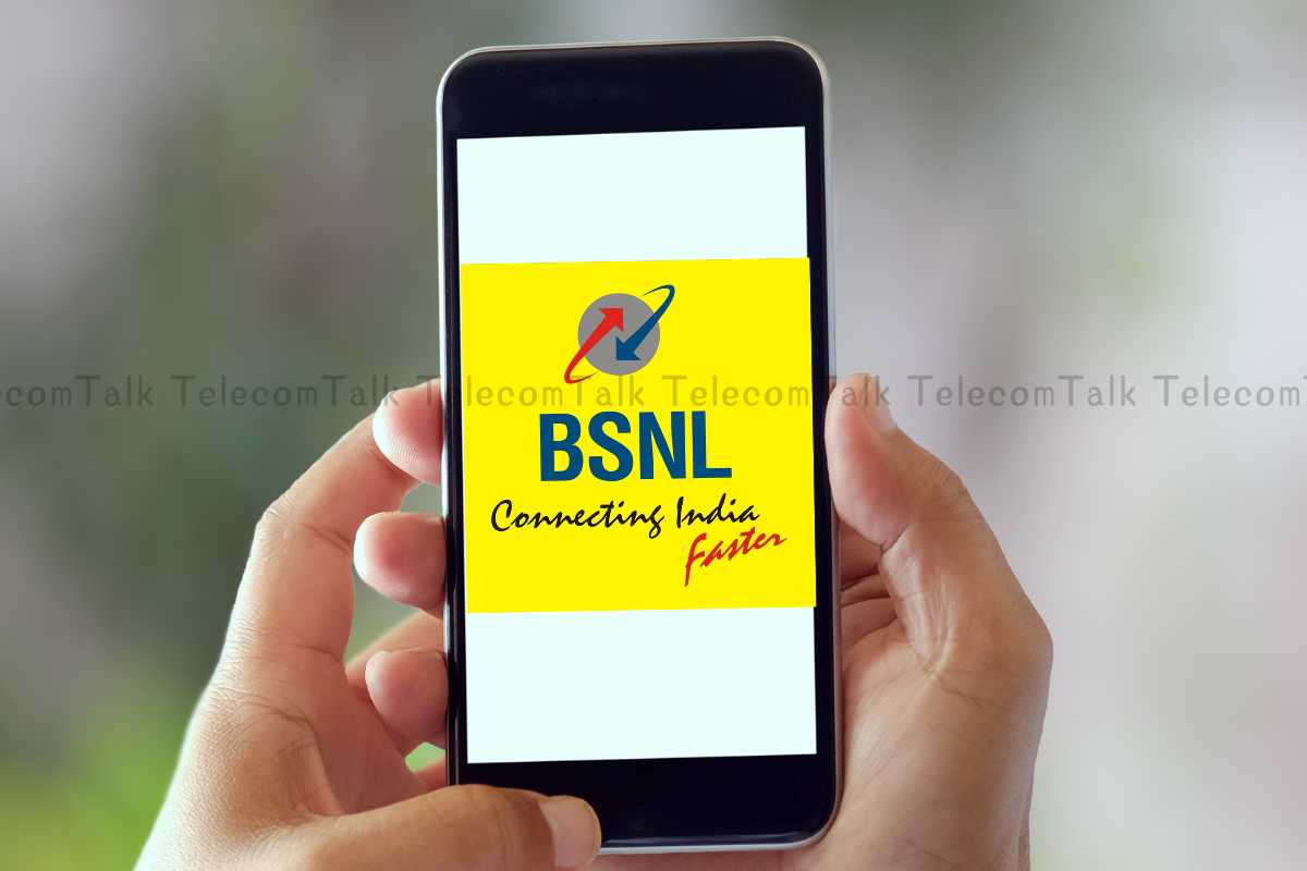 Hand holding phone with BSNL advertisement on screen.