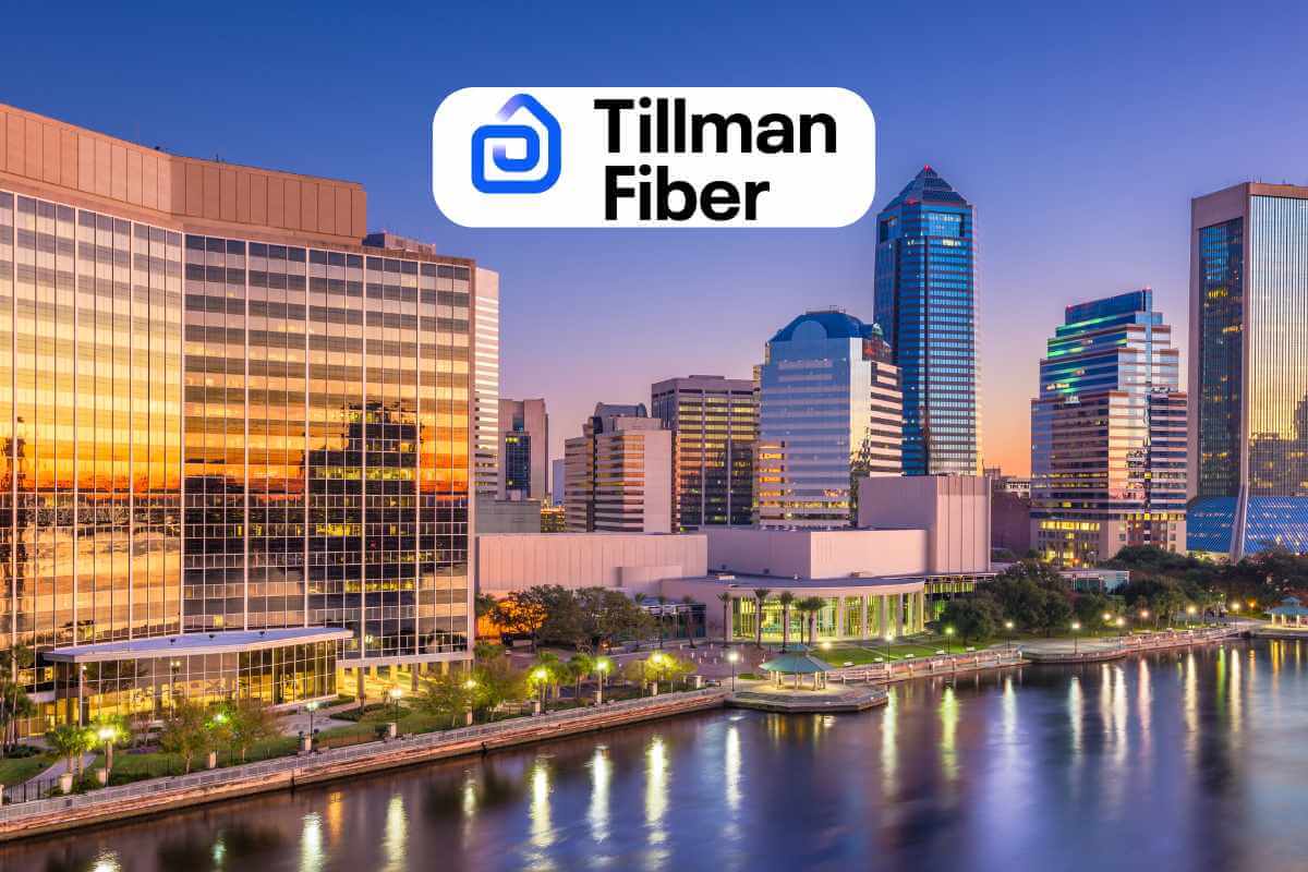 City skyline at sunset with Tillman Fiber logo.