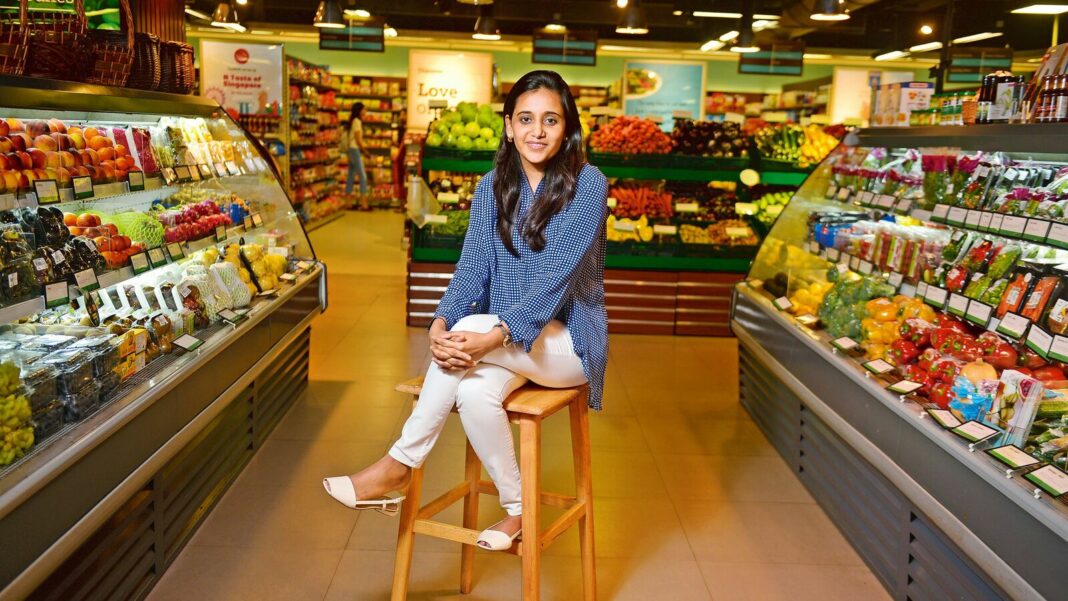 Woman smiling in vibrant grocery store aisle.