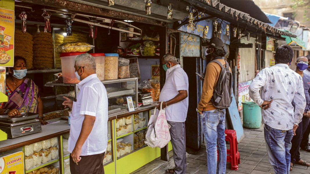 People shopping at street snack stall.