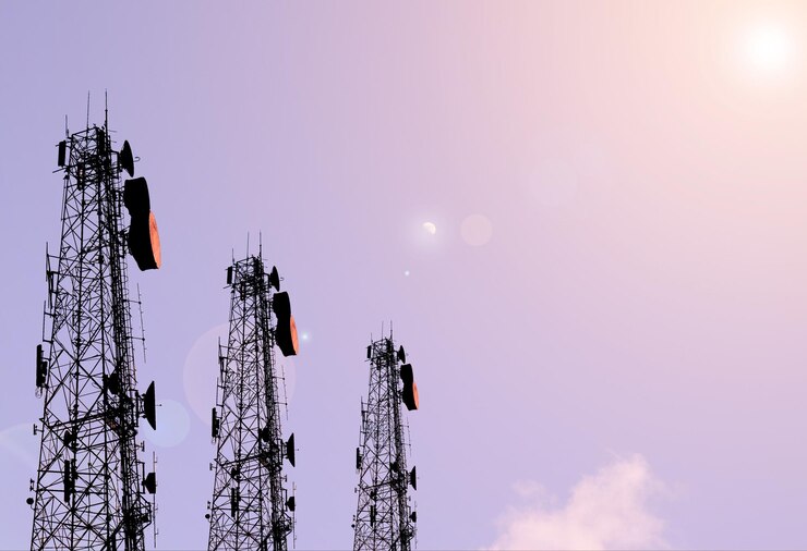 Cell towers silhouette against twilight sky.