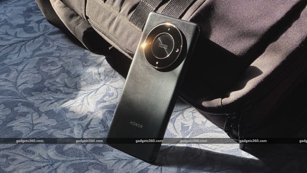 HONOR smartphone with circular camera design on fabric surface.