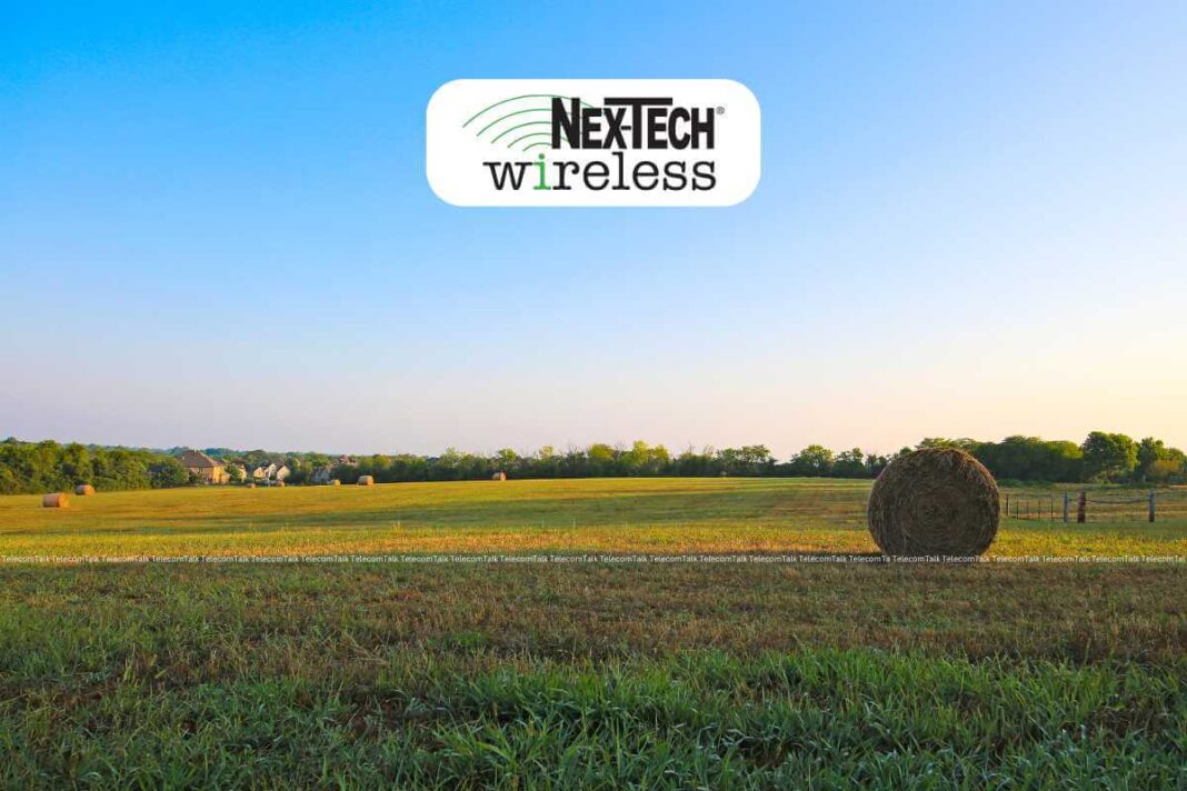 Rural field with hay bales and company logo.