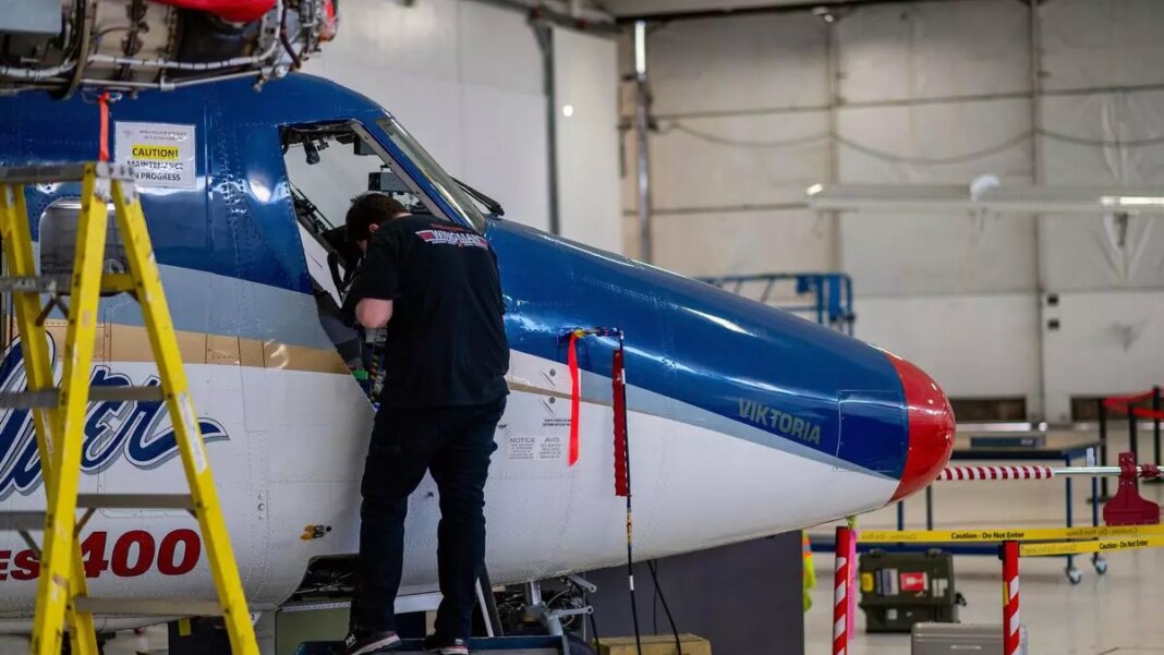 Technician performing maintenance on airplane nose.