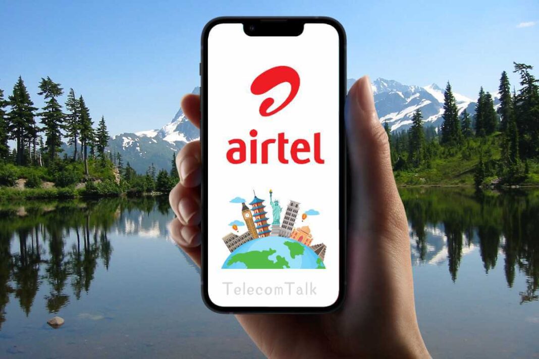 Hand holding phone with Airtel logo and scenic backdrop