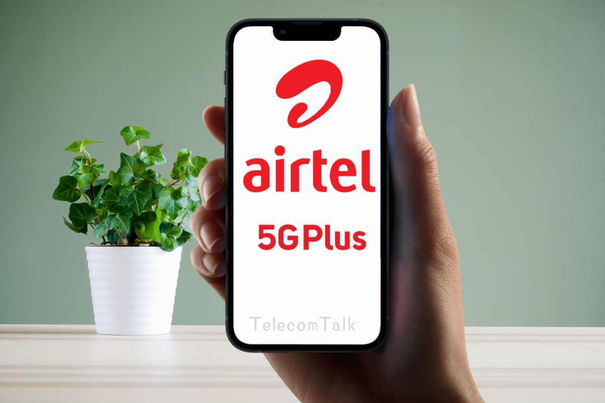 Hand holding phone with Airtel 5G Plus logo.