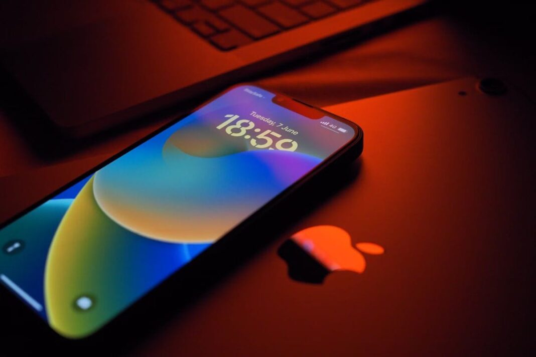 Illuminated smartphone on desk displaying colorful wallpaper.