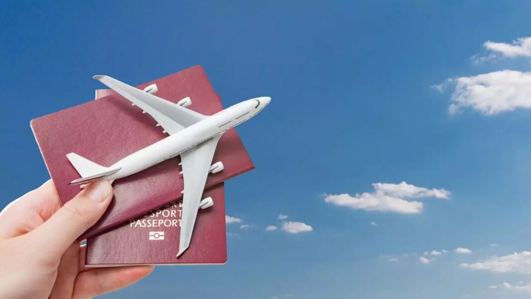 Hand holding passports and airplane model, travel concept.