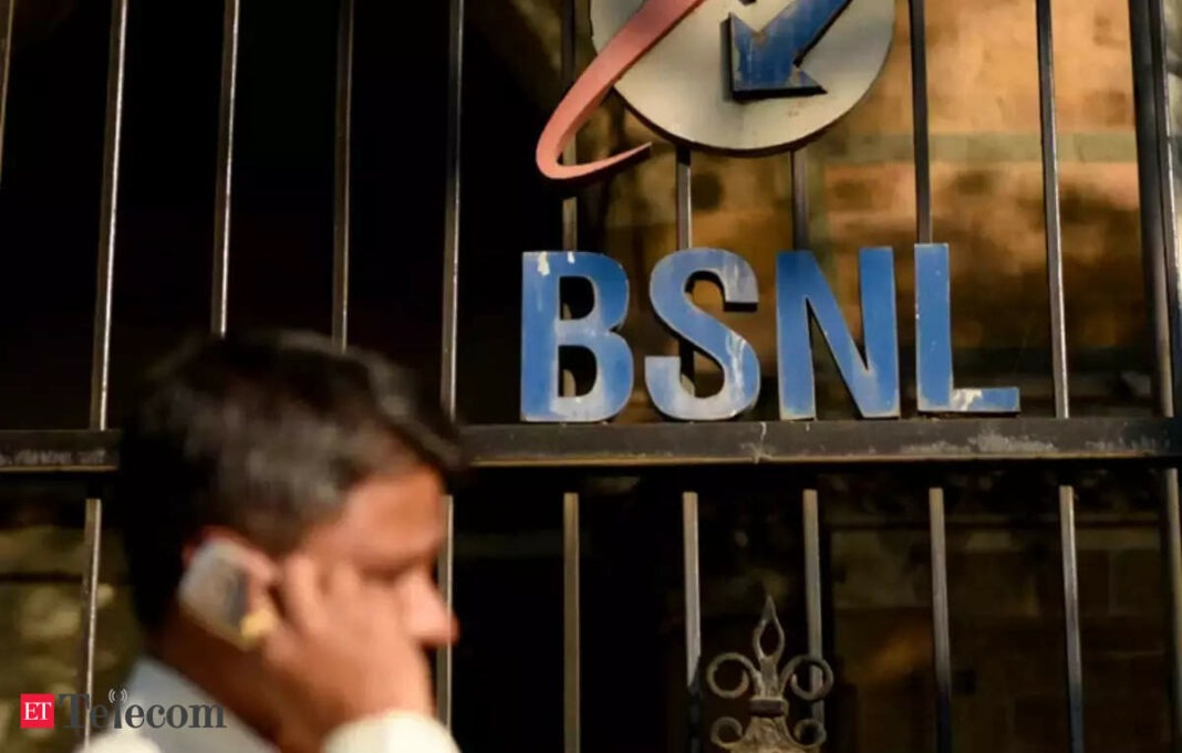 Person on phone near BSNL sign and gate.