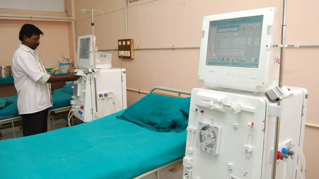 Medical professional operating dialysis machine in hospital.
