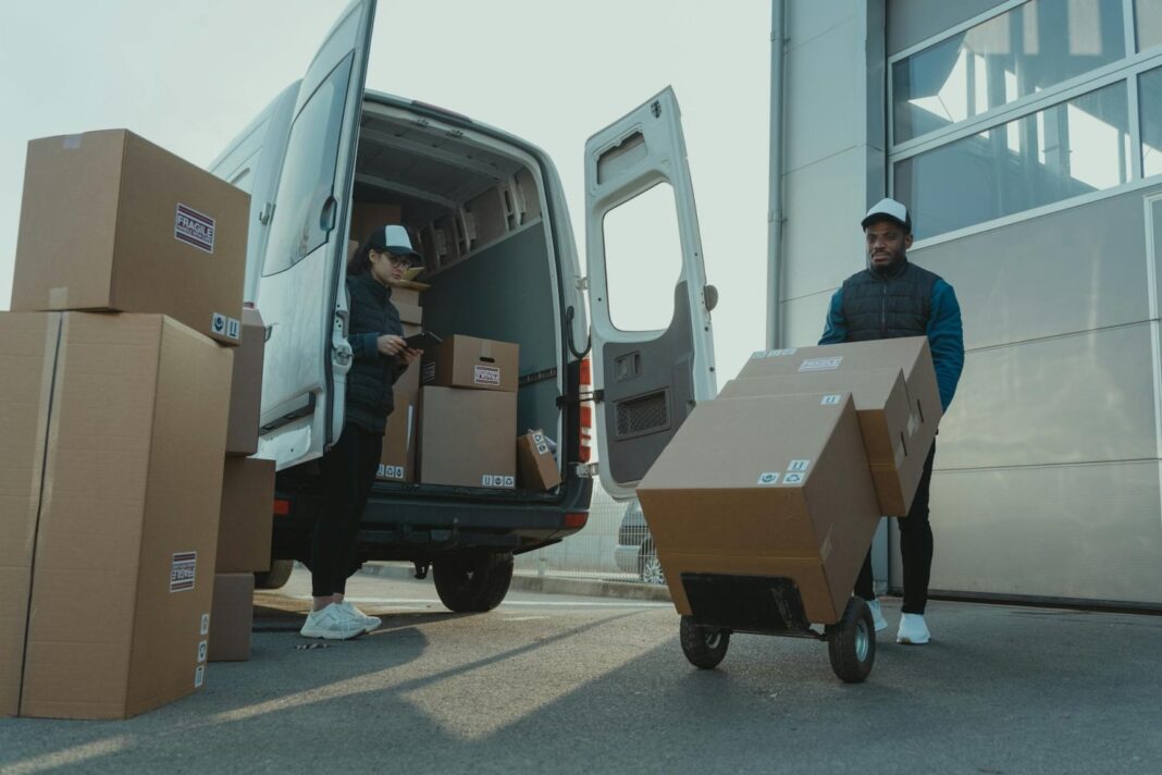 Delivery workers unloading boxes from van.