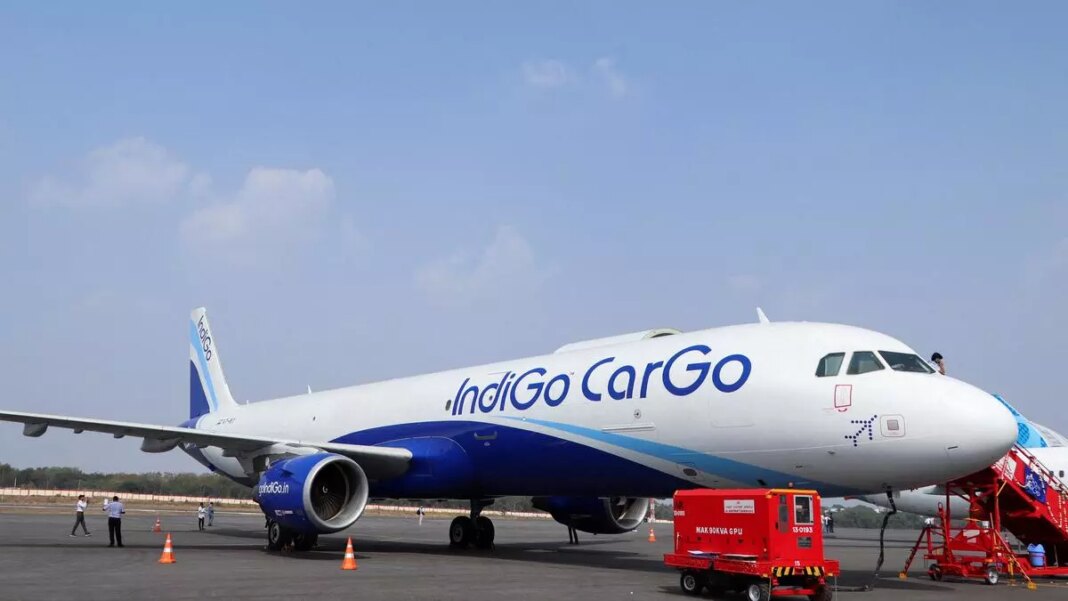 IndiGo Cargo airplane at airport with service vehicles.