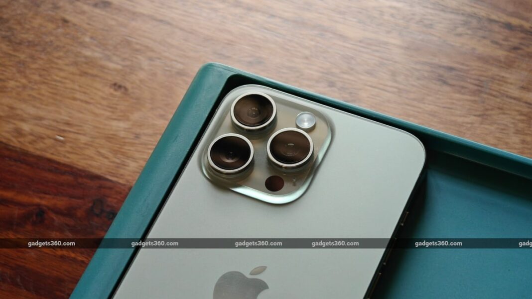 Close-up of smartphone camera lenses on wooden table.