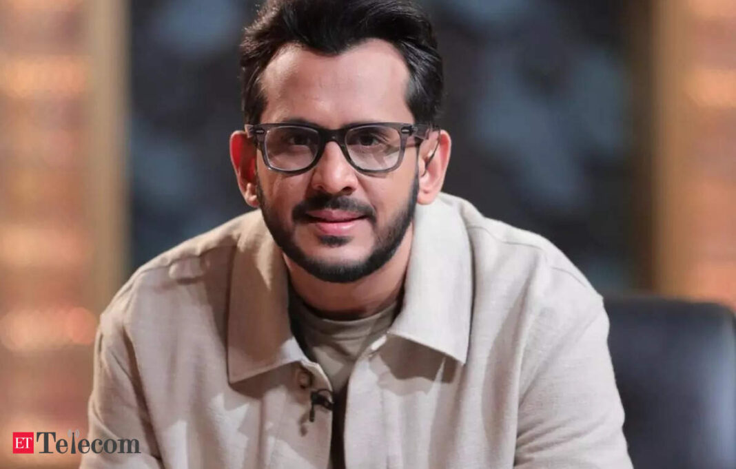 Man in glasses smiling during an interview.