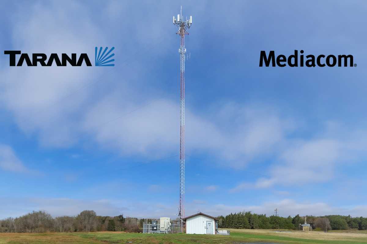 Cell tower in rural landscape with logos.