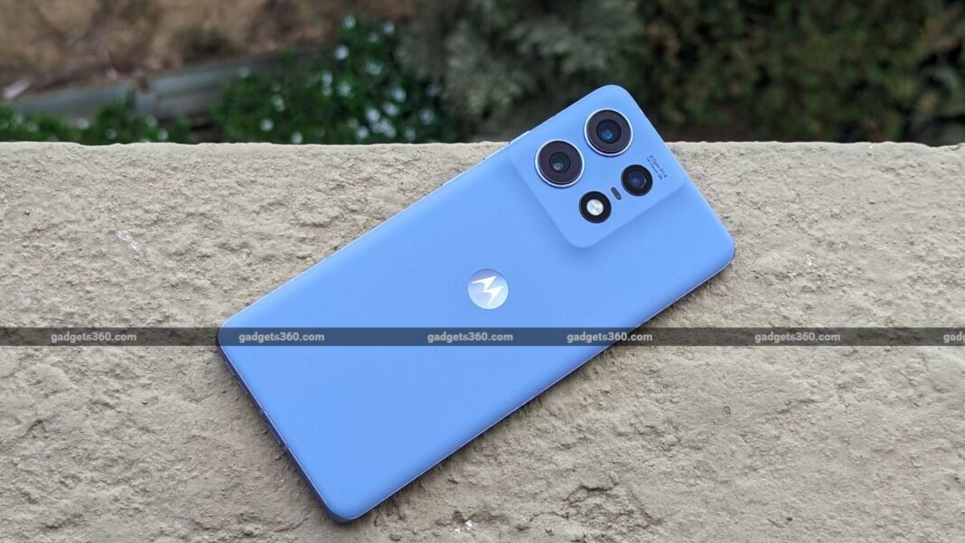 Blue smartphone with triple cameras on ledge.