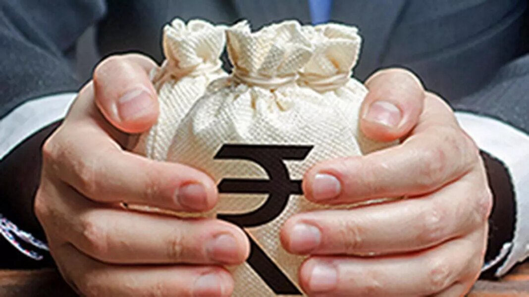 Hands holding money bag with rupee symbol.
