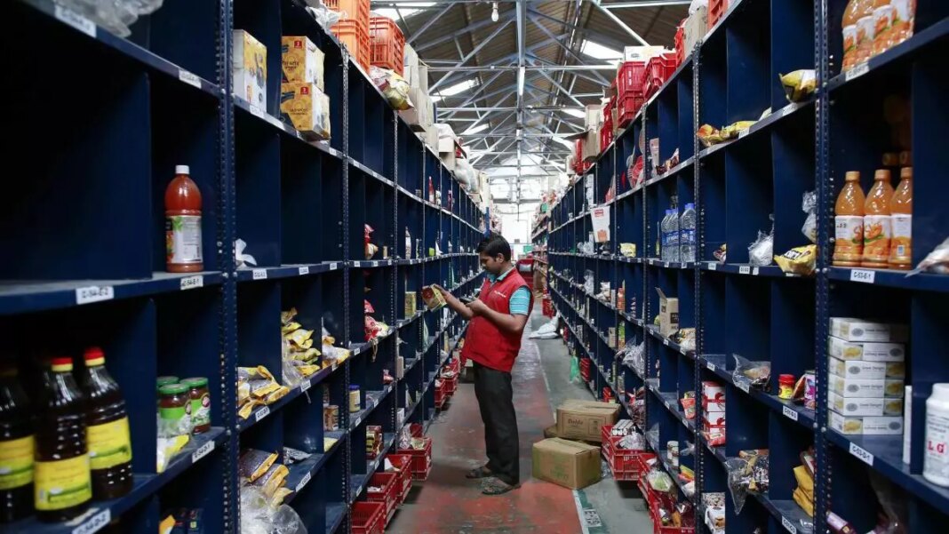 Worker stocking shelves in warehouse aisle.