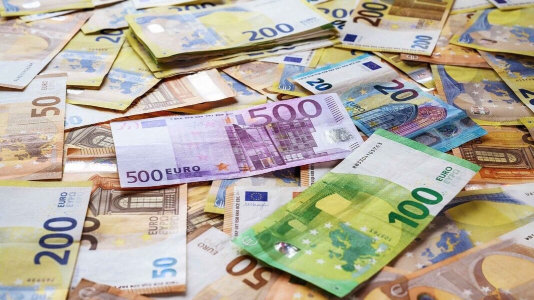 Assorted Euro banknotes spread out on surface.