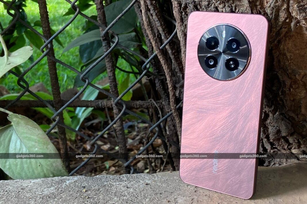 Smartphone with triple cameras leaning against tree.