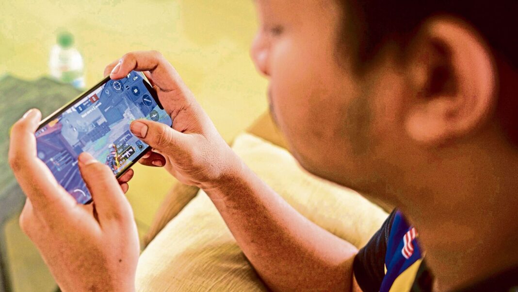 Person playing mobile game on smartphone.