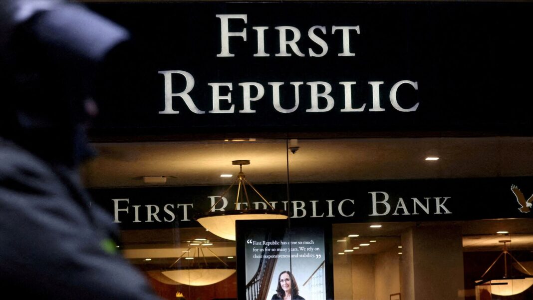 Silhouetted person near First Republic Bank sign at night.