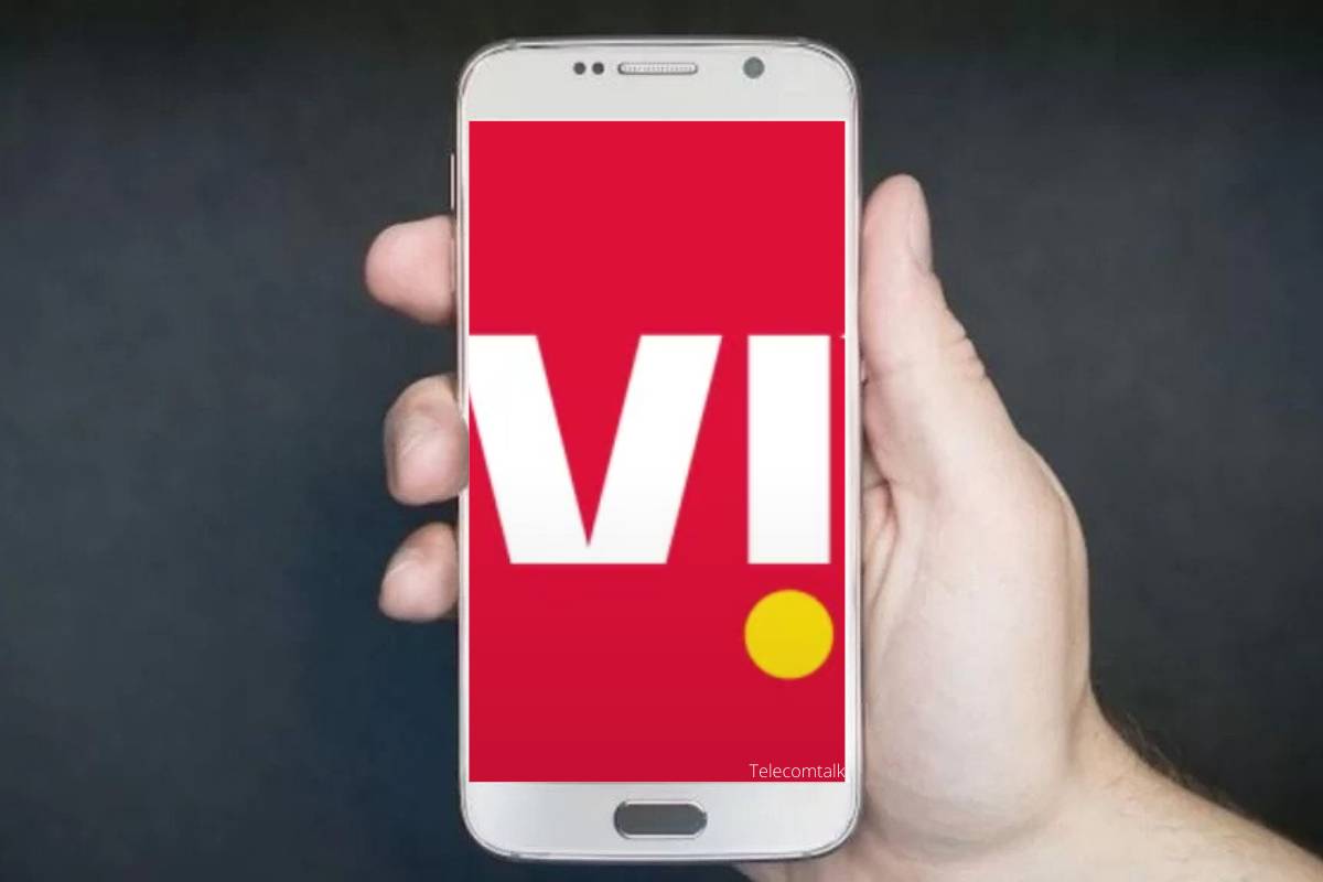 Hand holding smartphone with red and white logo.