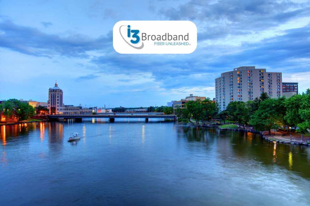 Twilight cityscape with river and i3 Broadband logo.