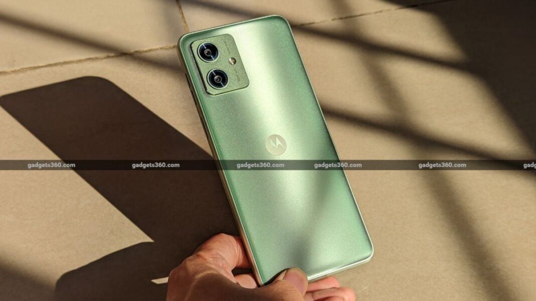 Hand holding a green Motorola smartphone.