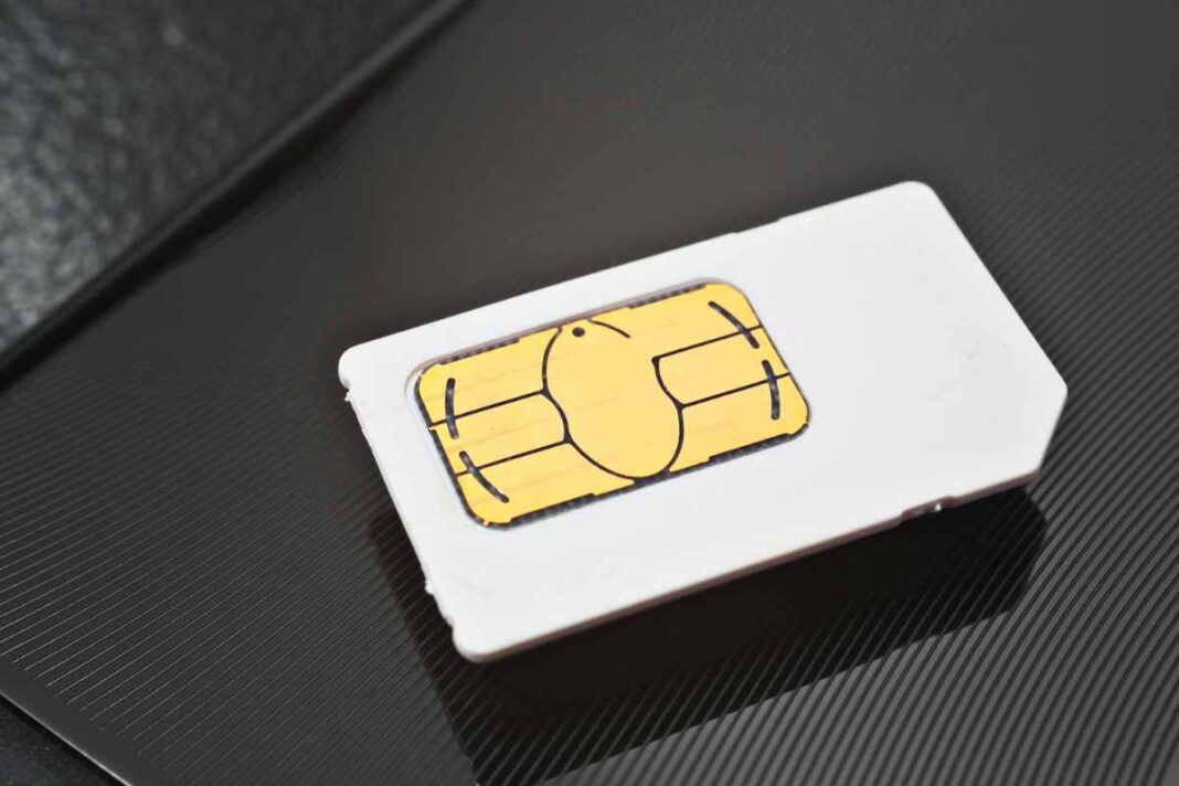 SIM card on black textured background.