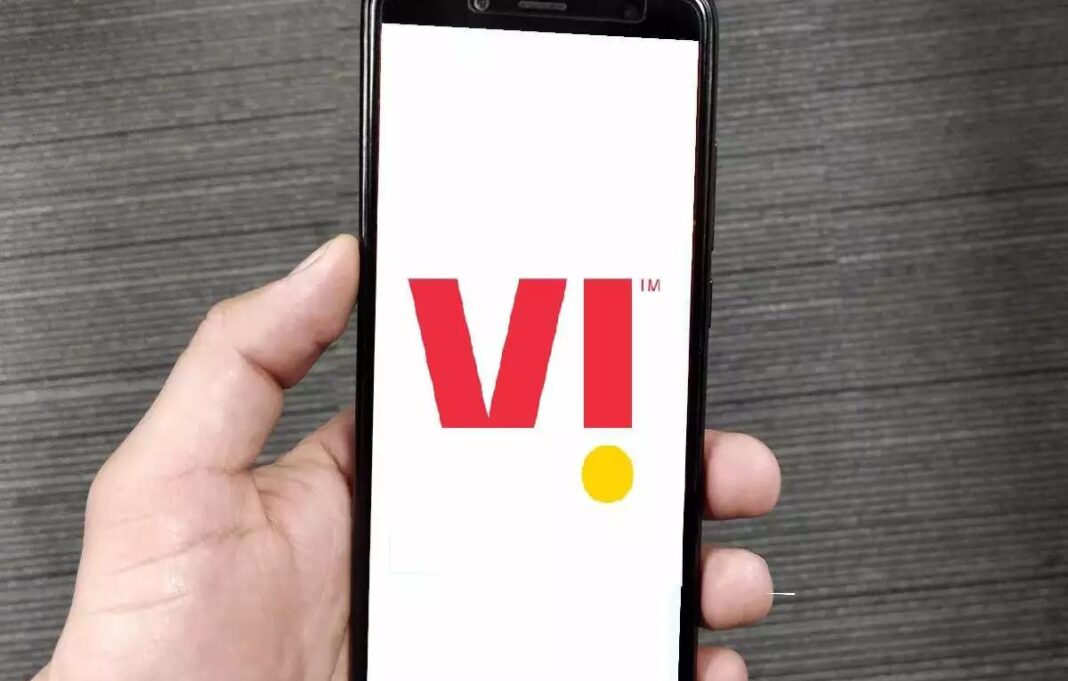Hand holding smartphone displaying logo on screen.