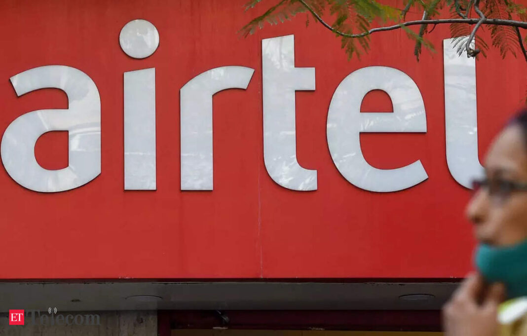Airtel logo on storefront with blurred person walking by.