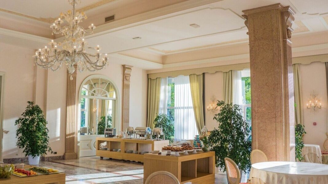 Elegant hotel banquet room with buffet and chandelier.
