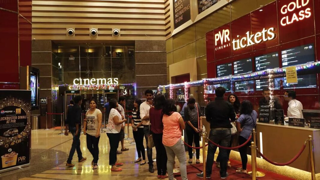 Moviegoers lining up at cinema ticket counter.