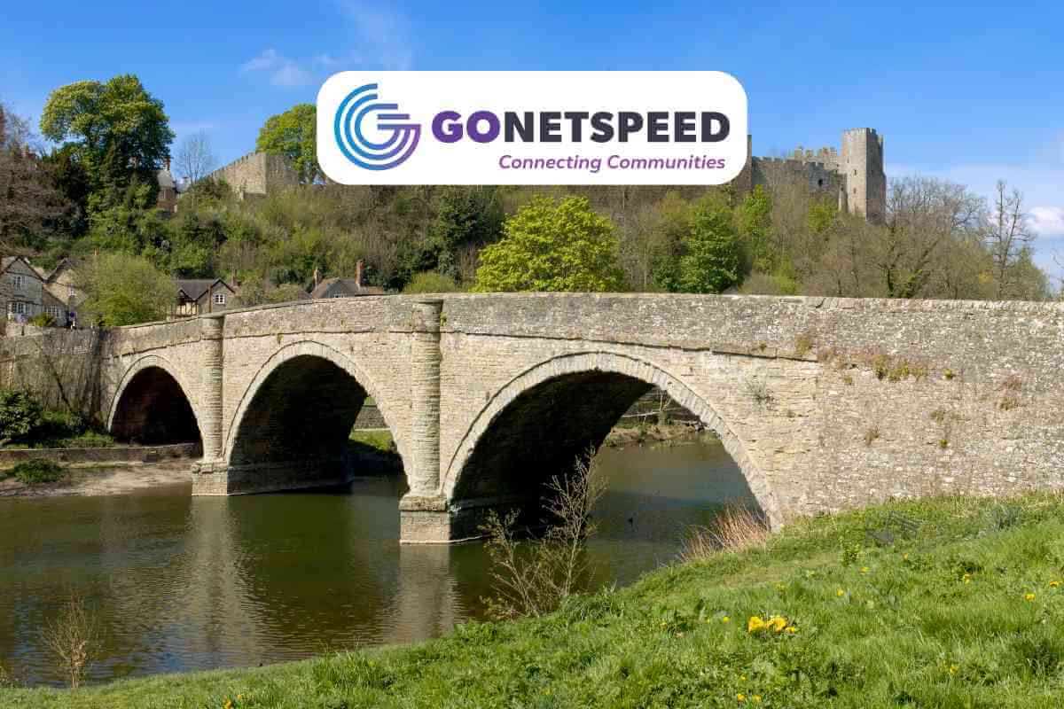 Stone bridge over river with GoNetspeed logo.