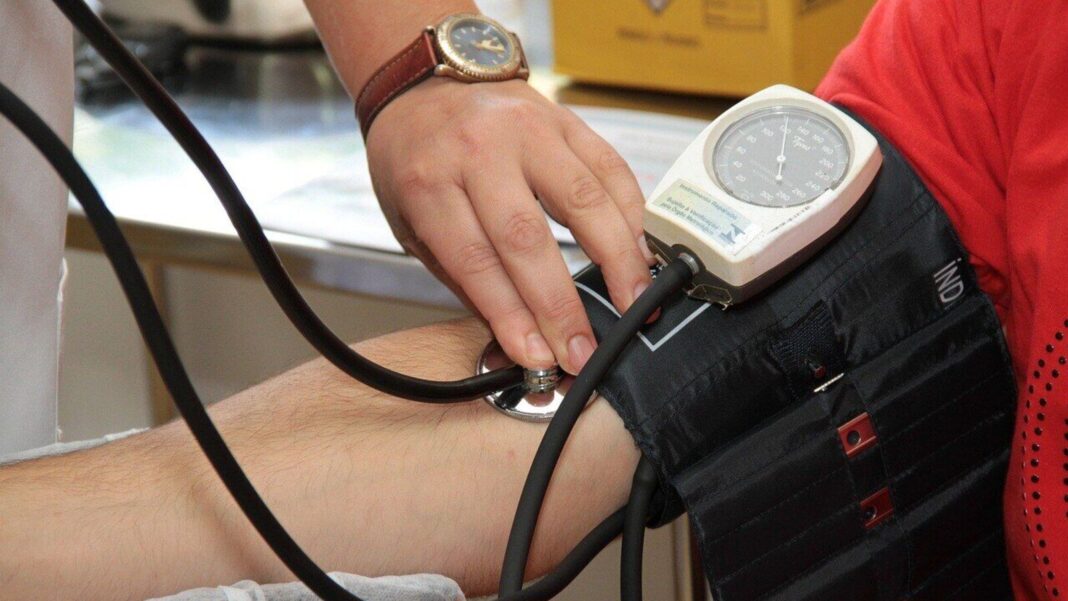 Taking blood pressure with sphygmomanometer.