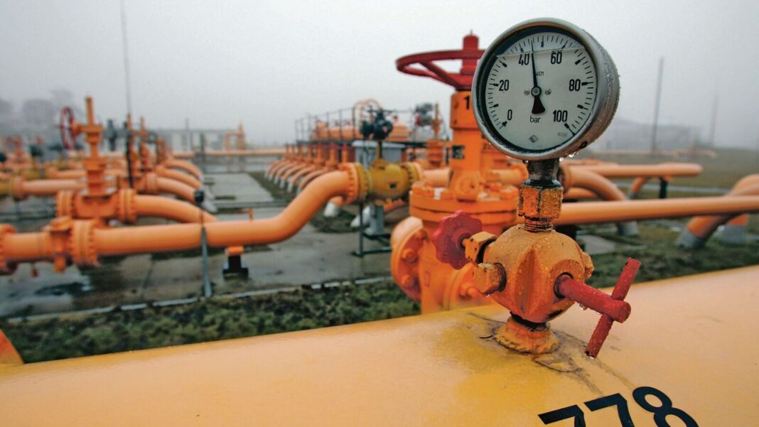 Industrial gas pipes and pressure gauge in foggy weather.