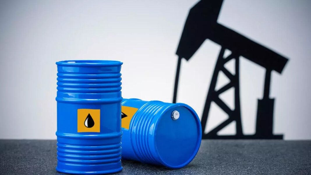 Blue oil barrels with pumpjack silhouette in background.