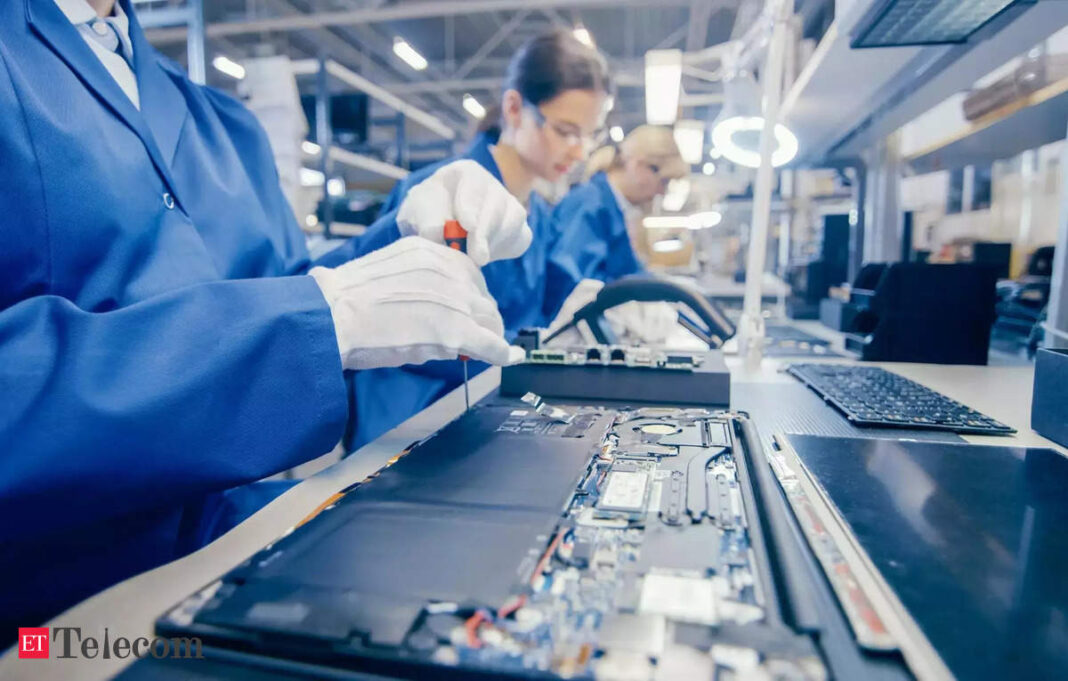 Technicians assembling electronics in factory.