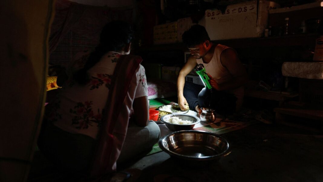 Two people preparing food in dimly lit room.