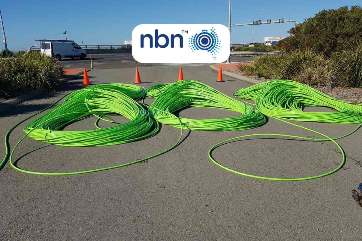 Green fiber optic cables on ground near NBN logo.