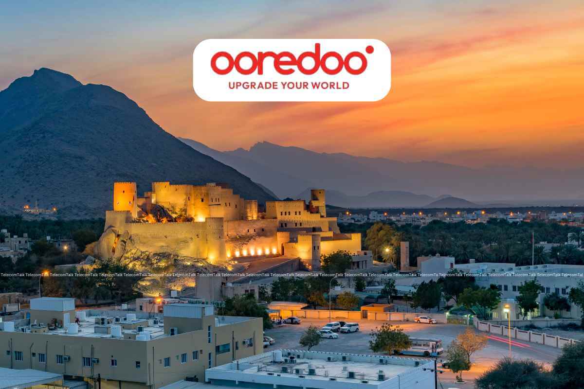 Ooredoo billboard above lit fortress at sunset.