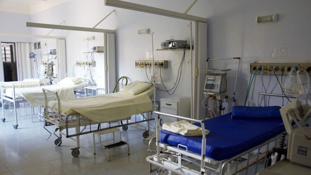 Hospital room with empty beds and medical equipment.