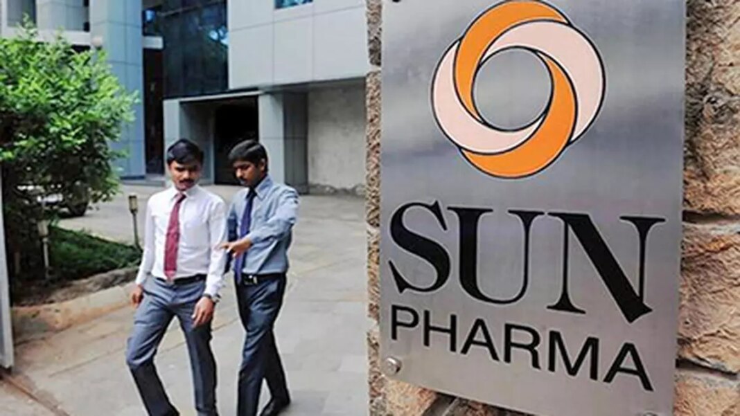Businessmen walking near Sun Pharma signboard.