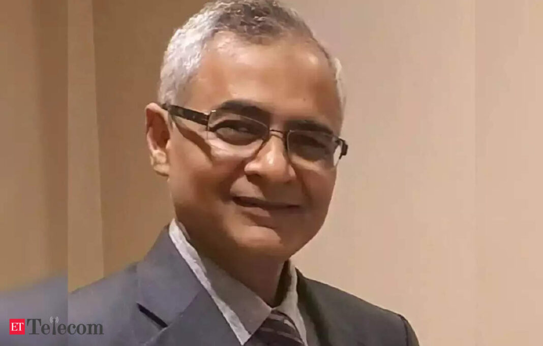 Smiling man with glasses in a suit.